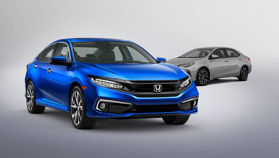 Vista frontal de 3/4 desde el lado del pasajero del Honda Civic Touring Sedan 2019 en Aegean Blue Metallic con un vehículo de la competencia en segundo plano.